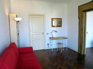 uma sala de estar com um sofá vermelho e uma mesa em Pretty panoramic apartment - half way Center-Vomero district em Nápoles