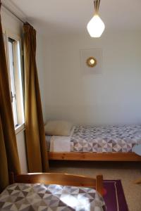 een kleine slaapkamer met een bed en een raam bij Maison Charrasse in Flassan