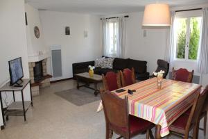 een woonkamer met een tafel en een bank bij Maison Charrasse in Flassan