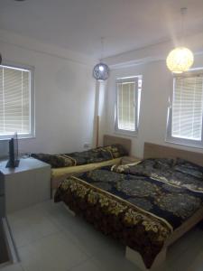 Cette chambre comprend 3 lits, une télévision et des fenêtres. dans l'établissement Kibar, à Ohrid