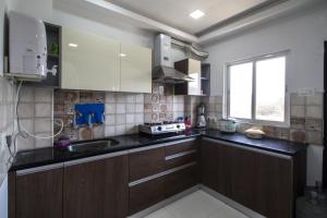 a kitchen with brown cabinets and a sink and a window at Hotel Brundavan Homes in Hyderabad