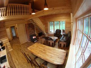 una vista aérea de una sala de estar con una mesa en una cabaña de madera en Koidu Puhkemaja en Suurevalja