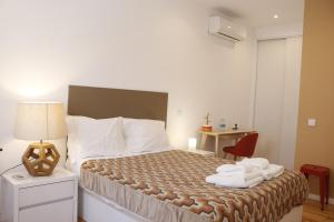 une chambre d'hôtel avec un lit et des serviettes. dans l'établissement Casa Malpique, à Albufeira