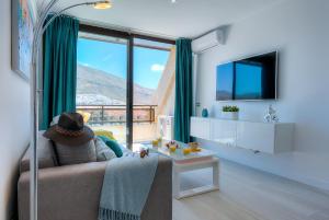 a living room with a couch and a large window at Modern Apartment Los Cristianos Center in Los Cristianos