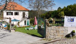 a gate to a house with a yard with chairs at Casa das Lages in Paredes de Coura +1 photo