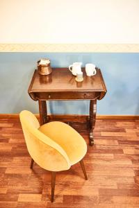 una mesa de madera con una silla amarilla junto a una mesa en Benignicase en Roma