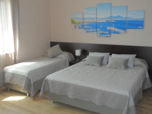 - une chambre avec 2 lits et un tableau mural dans l'établissement BELLAVISTA B&b, à Lamezia Terme