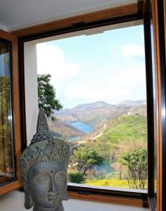 a large statue in front of a window with a view at Oak Cottage in Ferreira do Zêzere