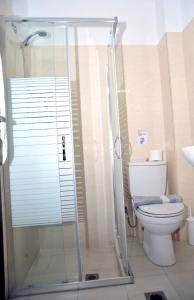 a bathroom with a toilet and a glass shower at Santa Marina Hotel Apartments in Kos