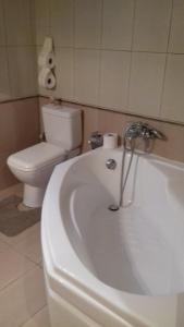 uma casa de banho com uma banheira branca e um WC. em Mila LA villa em Kástro Tornéze