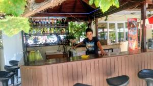 a man standing at a bar in a restaurant at Melodi Club Apart in Davutlar
