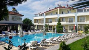 a hotel with a swimming pool and lounge chairs at Melodi Club Apart in Davutlar