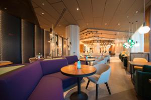 a restaurant with purple furniture and tables and chairs at Mercure Saransk Center in Saransk