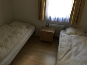 2 łóżka w małym pokoju z oknem w obiekcie Barga GP w Davos