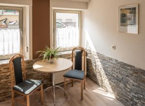 a table and chairs in a room with a brick wall at Gästezimmer Strauß in Kottenheim