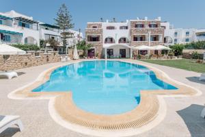 a large swimming pool in front of a building at Ariadne Hotel in Agios Prokopios