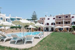 um grupo de cadeiras e guarda-sóis ao lado de uma piscina em Ariadne Hotel em Agios Prokopios