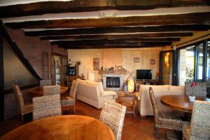 een woonkamer met tafels en stoelen en een open haard bij Agroturismo Maddiola in San Sebastian