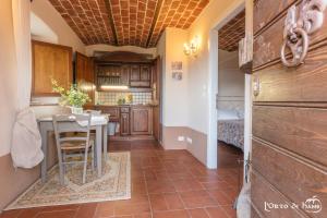 a kitchen with a table and a room with a bed at L'orto di Hans in Soriano nel Cimino