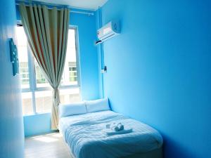 um quarto azul com uma cama em frente a uma janela em CJ Home em Sibu