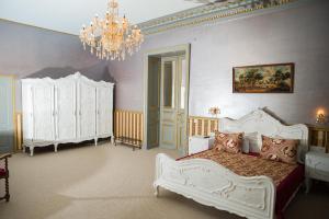 a bedroom with a white bed and a chandelier at NF Palace Old City Bucharest in Bucharest +172 photos