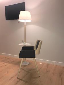 a table with a chair and a lamp in a room at IXUA Hotela in Éibar
