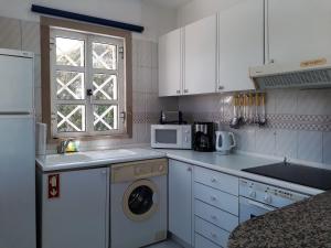 ヴィラモウラにあるAlgamar - Garagem, Ar-Condicionadoのキッチン(洗濯機付)、窓が備わります。