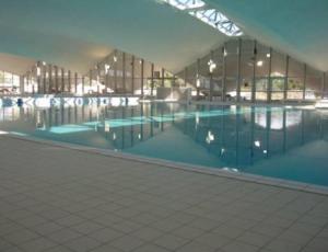 ein großes Schwimmbad in einem großen Gebäude in der Unterkunft Deauville Triangle d OR in Deauville