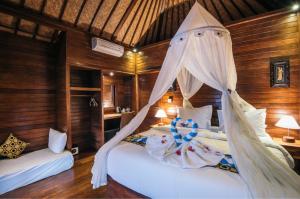a bedroom with two beds with mosquito nets at Lembongan Seaview in Nusa Lembongan