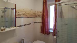 a bathroom with a shower and a toilet and a window at La casa del pescatore in Oliveri