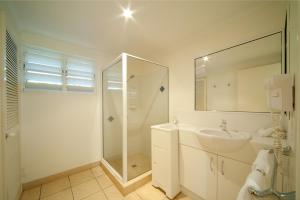 a bathroom with a sink, toilet and bathtub at Mango House Resort in Airlie Beach