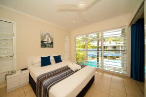 a hotel room with a bed and a window at Mango House Resort in Airlie Beach