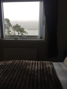 a bedroom with a bed and a window with a view at Lochalsh View en suite Kyle near Skye in Kyle of Lochalsh