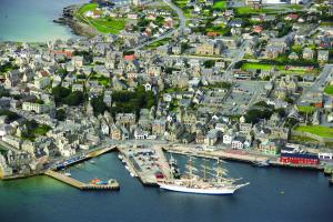 an aerial view of a harbor with a boat in the water at 16 Mounthooly Street in Lerwick +5 photos