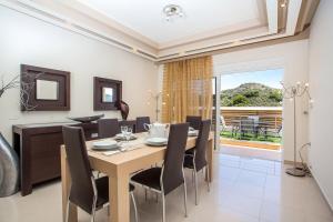 een eetkamer en woonkamer met een tafel en stoelen bij MeFoMi Villa in Rhodos-stad