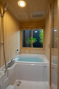 a bath tub in a room with a window at Kanade Fushimiinaribettei in Kyoto