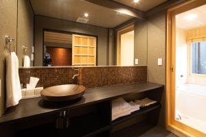 a bathroom with a sink and a large mirror at Kanade Fushimiinaribettei in Kyoto