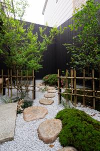 a garden with rocks and a fence at Kanade Fushimiinaribettei in Kyoto