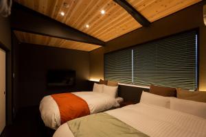 a bedroom with two beds and a window at Kanade Fushimiinaribettei in Kyoto