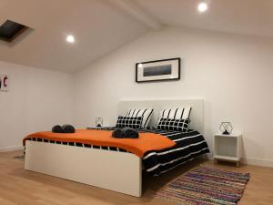 ポンタ・デルガダにあるAzores Summer Rentのベッドルーム1室(オレンジと黒の毛布のベッド1台付)