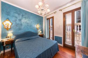 a bedroom with a bed and a blue wall at Hotel Pantalon in Venice