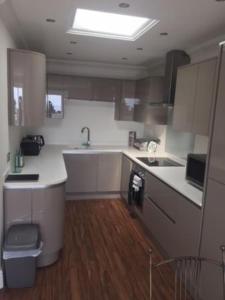 a kitchen with white counters and a sink at The Corbyn Apartments in Torquay