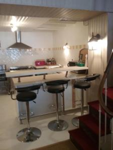 Una cocina con encimera y taburetes en una habitación. en 81 Rue des Juifs, en Granville