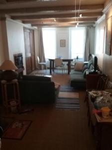 een woonkamer met banken en een eetkamer bij 81 Rue des Juifs in Granville