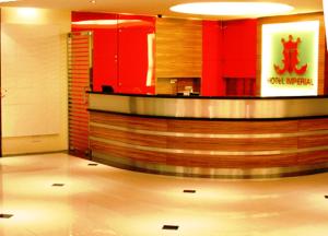 a hotel lobby with a reception counter and red walls at Hotel Imperial in Kuala Lumpur
