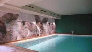 a swimming pool in a room with a mural of flowers at Mediterraneo Emotional Hotel & Spa in Santa Margherita Ligure
