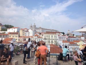 um grupo de pessoas de pé em uma varanda com vista para uma cidade em Little Alfama Town em Lisboa