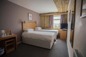 a hotel room with two beds and a television at Royal Hotel, Bar & Grill in Purfleet