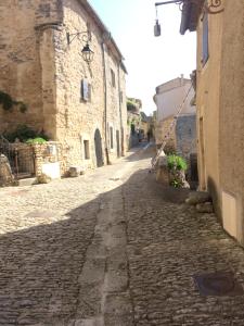 an empty street in an old town with buildings at L'Oustaou de Rose in Bonnieux