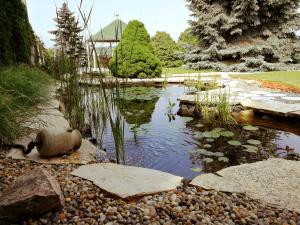 a pond in the middle of a garden at Elisoria Apartments in Cserszegtomaj